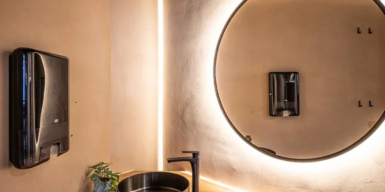 Nice and clean toilet and a round mirror