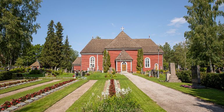 Teisko church's facade is made of red wood paneling.