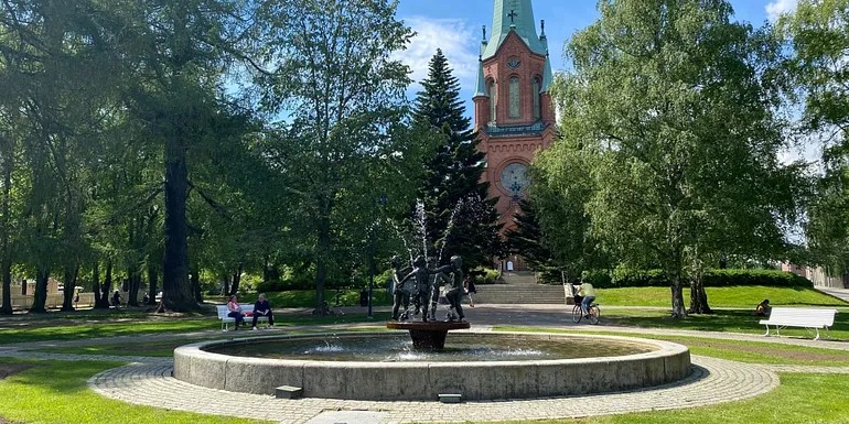 Towering Alexander Church behind a park fountain.