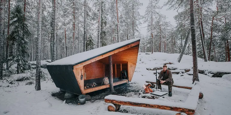 Mies istuu laavulla.