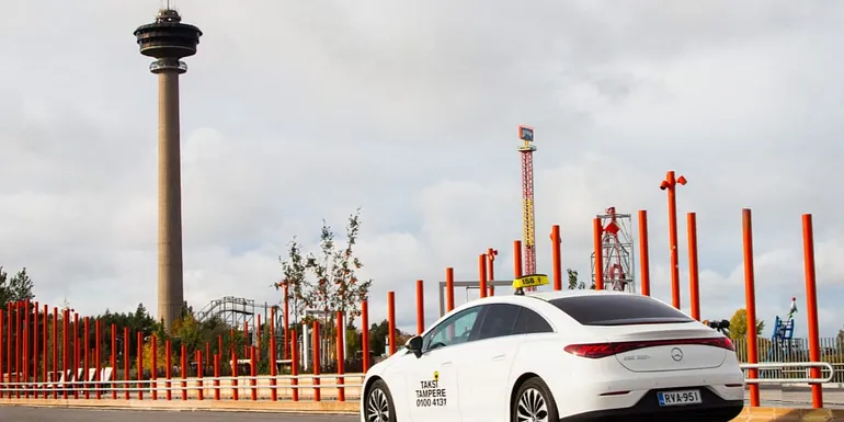 A Taksi Tampere taxi standing still with the Näsinneula Tower visible in the background.