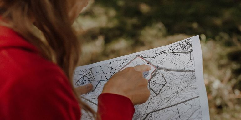 Nainen tutkii karttaa Tiitiäisen metsästä