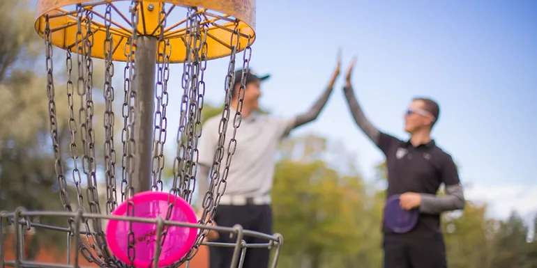 Men playing disc golf.