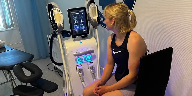 kuvassa on lihasstimulointilaite ja henkilö hoidossa