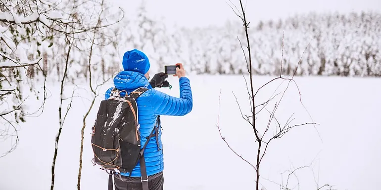 Mies valokuvaa talvista maisemaa.