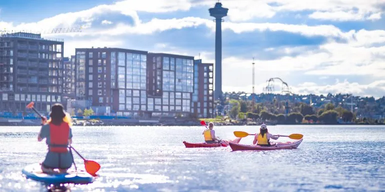 Canoeing on the lake next to urban city view