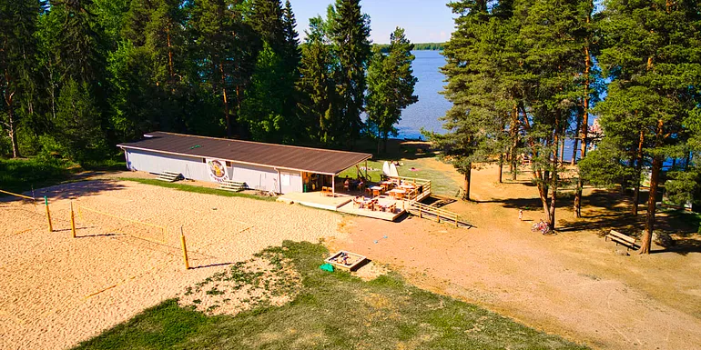 Ilmakuva Luttusen uimarannasta, jossa näkyy saunarakennus ja beach volley-kenttää