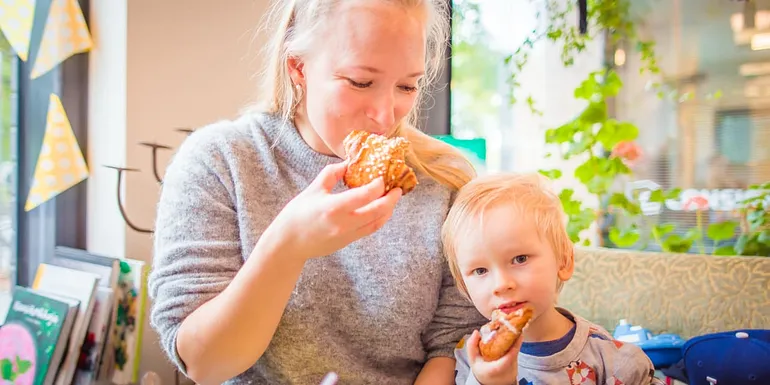 A woman and a child enjoying delicious Finnish cinnamon buns at Bakery Cafe Puusti, Tampere, Finland