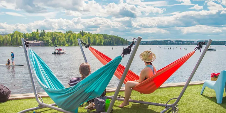 People looking at water activities in summery Eteläpuisto park.