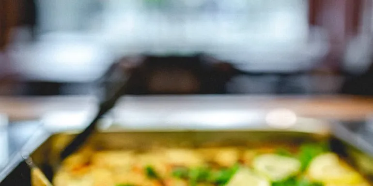 Kuvassa lounaskattauksesta broilerikiusausta, jonka päällä limetin siivuja. Lähikuva.