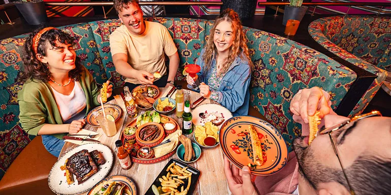 Iloinen seurue ruokailemassa