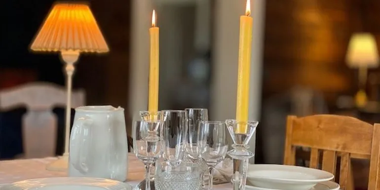 Kauniisti katettu pöytä, jossa kaksi kynttilää
