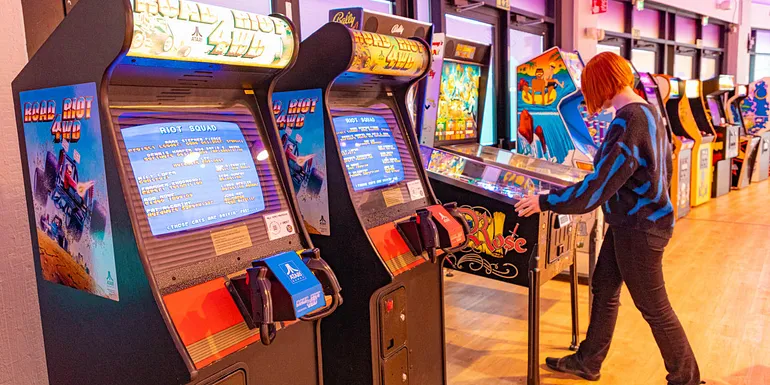 A white red-haired woman playing in Retro Arcade