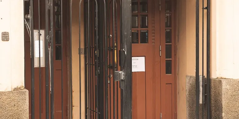 Entrance to a pub, wooden door, old metal gate, red carpet