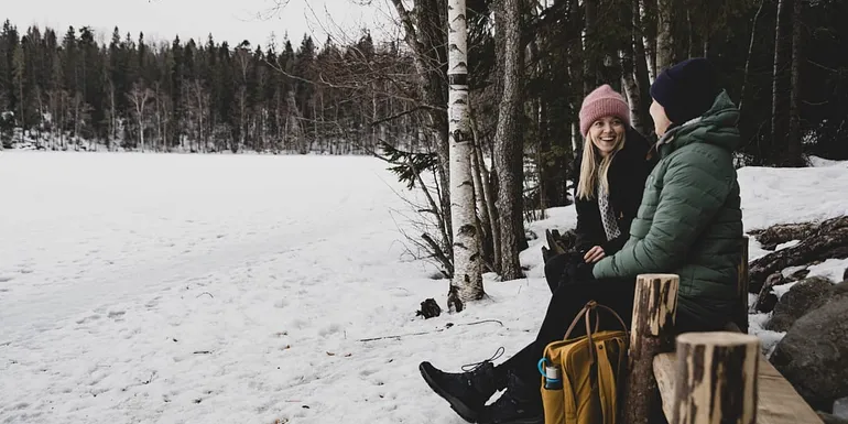 Nainen ja lapsi katsovat istuen jäätynyttä Hervannan Suolijärveä mielenreitillä.