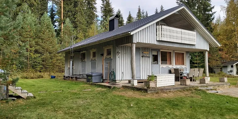 Huvila on järven rannalla, iso tasainen piha.