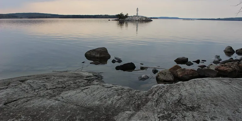 Rantakalliot ja pieni saari, jossa merimerkki