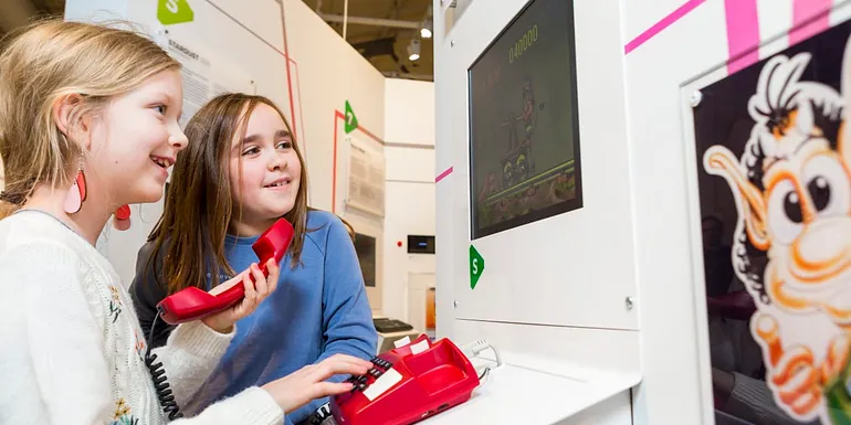 Children playing with a landline phone.